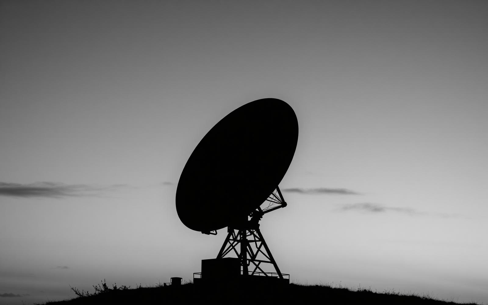 Antena parabólica via satélite ao entardecer em área rural